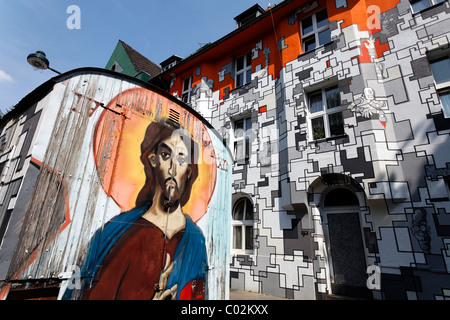 Gesù graffiti su on-site il rimorchio e case di ex occupanti abusivi, artisticamente facciate dipinte in street art style Foto Stock