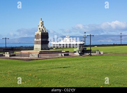 Il Largs Memoriale di guerra per commemorare i caduti nelle due guerre mondiali con traghetto CalMac avvicinando Largs pier in background Foto Stock