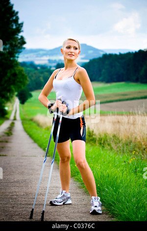 Giovane donna facendo Nordic walking Foto Stock