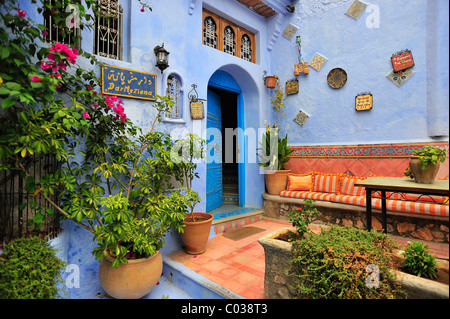 La porta anteriore di una casa con una zona salotto e piante, Chefchaouen, Reef montagne, Marocco, Africa Foto Stock