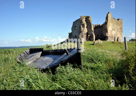 Barca su un mare Baltico spiaggia davanti alle rovine del castello dell'Ordine dei Cavalieri Teutonici, Toolse, Estonia Foto Stock