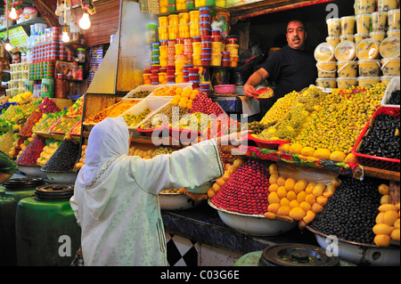 Donna anziana indossando un velo in una fase di stallo nel souk mercato o bazaar, Meknes, Marocco, Africa Foto Stock