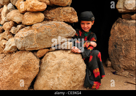 Piccola ragazza berbero di una famiglia nomade all'entrata di una casa, Kelaa M' gouna, Alto Atlante, Marocco, Africa Foto Stock