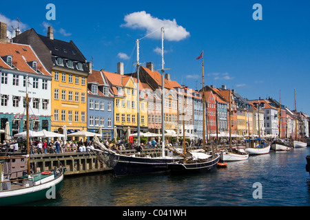 Una folla di persone mangiare il pranzo presso i ristoranti lungo Nyhavn o un nuovo canale del porto di Copenhagen, Danimarca. Foto Stock