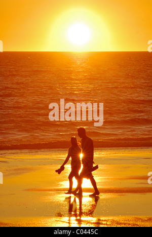 Un paio di camminare sulla spiaggia di Cable Beach, Broome, Western Australia al tramonto Foto Stock