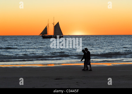 Un paio di camminare sulla spiaggia di Cable Beach, Broome, Western Australia al tramonto Foto Stock