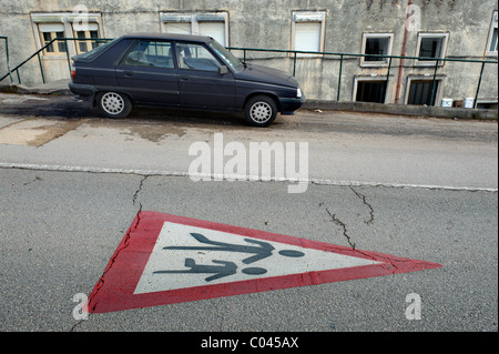 Segno di traffico per i bambini della scuola attraversando dipinta su una pavimentazione stradale Foto Stock