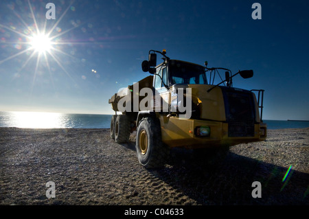 Una campana B30D Caterpillar Dumper su Seaford beach, East Sussex, aiutando a combattere l'erosione ripristinando i livelli di ghiaia. Foto Stock