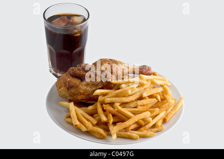 Piatto di pollo fritto con patatine fritte accanto a un freddo cola. Isolato Foto Stock