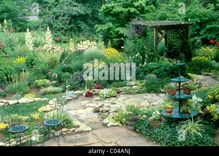 Giardino formale con mano costruito arbor e antichi mobili in ferro battuto e piantatrice, indipendenza MO USA Foto Stock