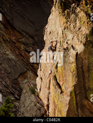 Una giovane ragazza segue il suo partner fino a difficile arrampicata sul Bastille in Eldorado Canyon (Eldo), al di fuori di Boulder, CO. Foto Stock