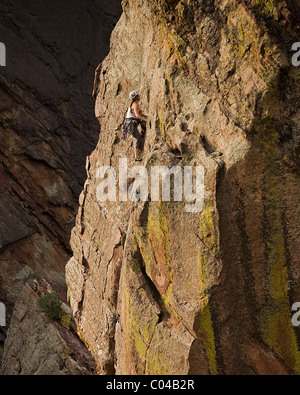 Una giovane ragazza segue il suo partner fino a difficile arrampicata sul Bastille in Eldorado Canyon (Eldo), al di fuori di Boulder, CO. Foto Stock