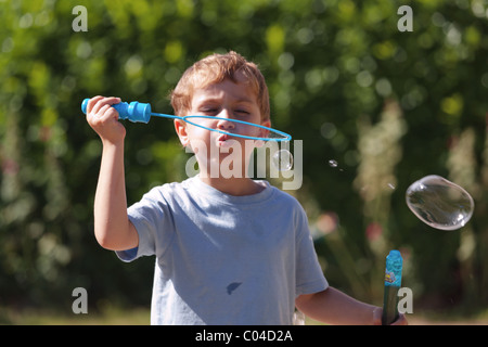 Ragazzo giovane soffiare bolle. Foto Stock