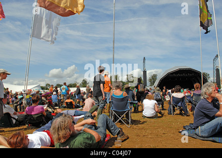 Persone e rilassante guardando una performance DEL FESTIVAL WOMAD, Malmesbury, Wiltshire, Regno Unito Foto Stock