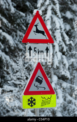 Cartello stradale avverte in inverno di neve e di ghiaccio sul fondo stradale sdrucciolevole Foto Stock