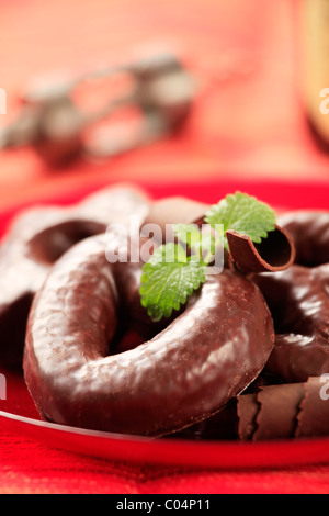 Ricoperta di cioccolato gingerbread cookie su una targhetta rossa Foto Stock