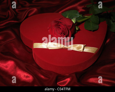 Cuore rosso a forma di scatola regalo e una rosa rossa Foto Stock