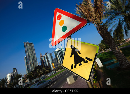 Attraversamento pedonale cartello stradale su Al Corniche Street, Doha, Qatar che mostra una figura in arabo abito con semaforo davanti Foto Stock