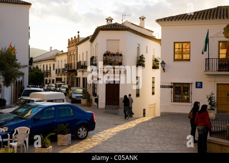 Piazza centrale di spagnolo villaggio bianco di Zahara, con edifici e persone al crepuscolo / Tramonto / sun set. Zahara, Spagna. Foto Stock