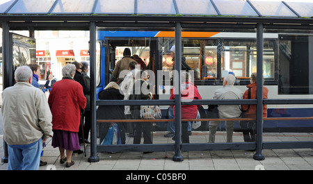 I pensionati in attesa o di salire a bordo di un autobus in Worthing West Sussex Regno Unito Foto Stock