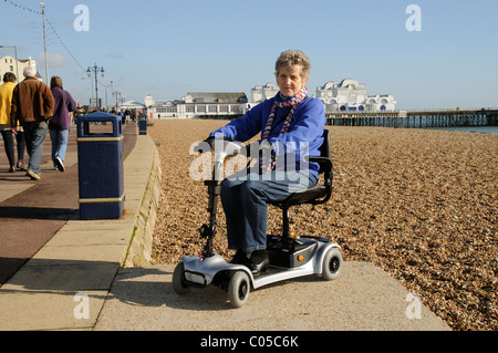 Mobilità utente scooter a cavallo di un ultra leggero e alimentato a batteria per la macchina sul lungomare di Southsea Southern England Regno Unito Foto Stock