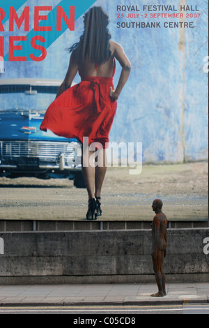 Antony Gormley scultura davanti a Carmen Jones poster. Parte dell'orizzonte di evento installazione, Southbank, Londra UK. 2007. Foto Stock