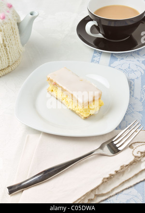 Il tè del pomeriggio con crema pasticcera slice e copriteiera coperto tè pentola. Foto Stock