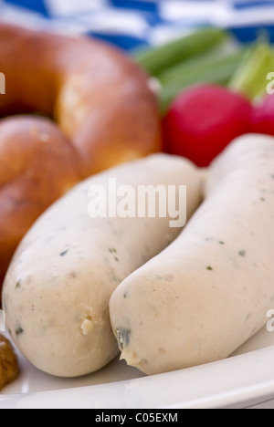 La salsiccia con Pretzel e senape dolce come primo piano su una piastra bianca Foto Stock