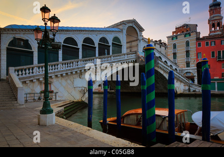 Il sole sta salendo al di sopra del ponte di Rialto sul Canal Grande, Italia Foto Stock