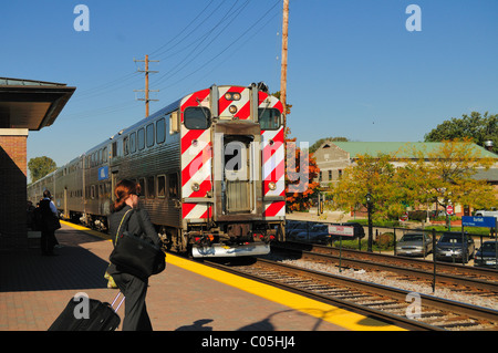 Metra treno dei pendolari che arrivano a Chicago suburbana stazione di Bartlett come pendolari si muovono a bordo del treno quando si arresta. Bartlett, Illinois, Stati Uniti d'America. Foto Stock