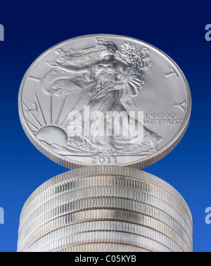 Una pila di 2011 uno oncia di noi silver Eagle monete con un equilibrato sulla parte superiore. Foto Stock