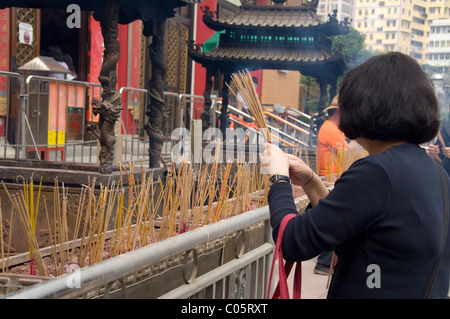 Cina, Hong Kong, nuovi territori. Sik sik Yuen Wong Tai Sin Temple. La gente del posto bruciando incenso davanti al tempio. Foto Stock