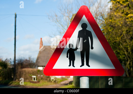 Cartello stradale di avvertimento di pedoni presente Foto Stock