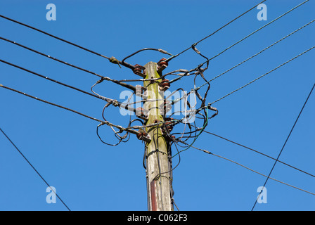 Un "telegrafo polo' con molte utilità di overhead di cavi di alimentazione o i fili su di essa, contro un cielo chiaro. Foto Stock