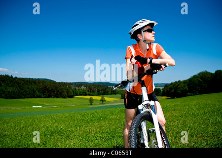Donna con moto prendendo una pausa in un prato Foto Stock