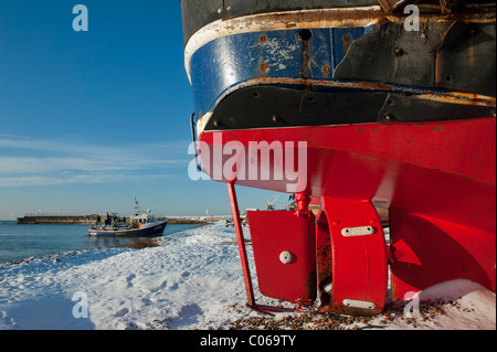 Barche da pesca su una coperta di neve spiaggia ghiaiosa Hastings East Sussex England Regno Unito Foto Stock