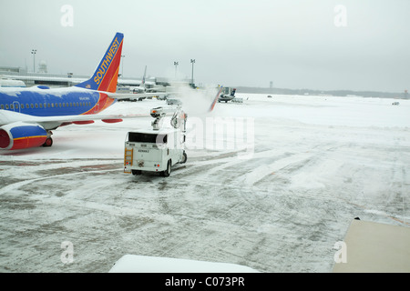 Come la grande tempesta di neve facilita un aeroplano riceve un de-icing a preparare per il volo Foto Stock