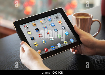 Vista ravvicinata di un man mano che tiene un iPad che mostra la schermata di applicazione ad un cafe Foto Stock