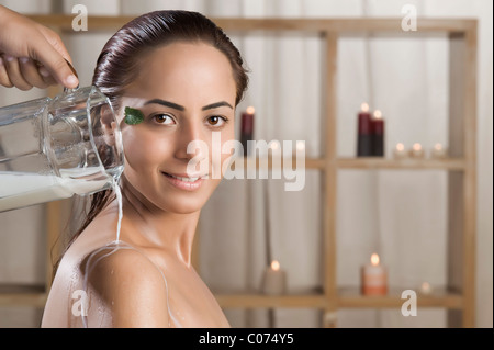 Donna di prendere un bagno di latte in una spa salute Foto Stock