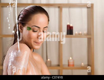 Donna di prendere un bagno di latte in una spa salute Foto Stock