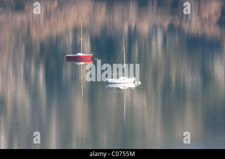 Due ormeggiate barche a vela nei riflessi del lago di Sainte-Croix vicino Verdon, Provenza, Francia Foto Stock