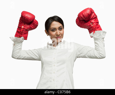 Imprenditrice in guantoni da pugilato tifo con le braccia sollevate Foto Stock