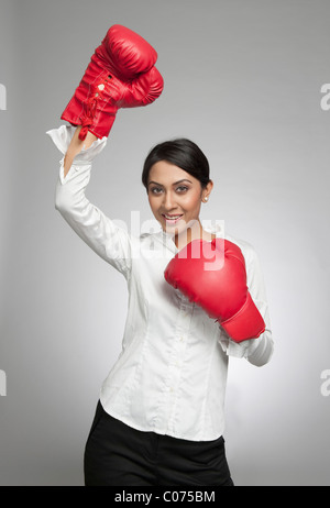 Imprenditrice in guantoni da pugilato tifo con la mano alzata Foto Stock