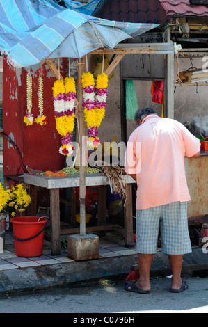 L'uomo fare ghirlande di fiori freschi al di fuori dello Sri Mahamariamman tempio indù di jalan bandar vicino a Petaling Street Kuala Lumpur Foto Stock