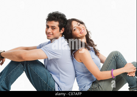 Giovane seduto di schiena e sorridente Foto Stock