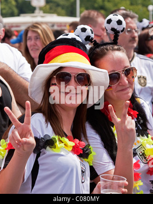 Due donne appassionati di calcio che frequentano la proiezione pubblica di fronte allo Stadio Olimpico durante la Coppa del Mondo FIFA 2010, guardando Foto Stock