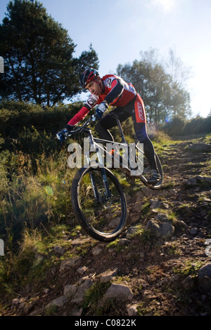 Mountain Biker scorre giù per un sentiero sterrato nel Regno Unito Foto Stock
