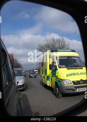 Speeding Ambulance guardato in un'automobile alare specchio, Regno Unito. Foto Stock