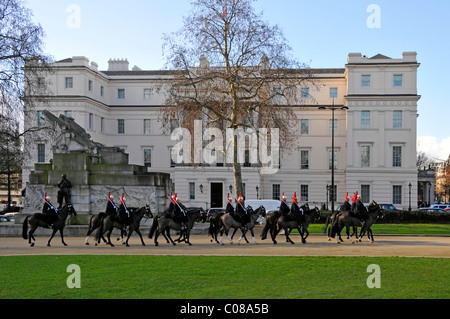 Famiglia cavalli di cavalleria & troopers passando Lanesborough Hotel 5 stelle lusso costoso hotel sul cielo blu giorno inverno alberi Hyde Park Corner London REGNO UNITO Foto Stock