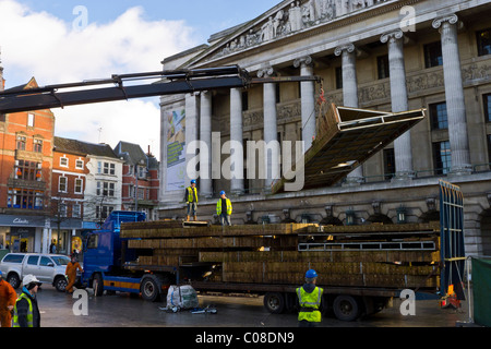 Operai lavorano con una gru e il carrello per preparare nottingham piazza del mercato per la fiera del divertimento a scuola a metà termine febbraio 2011 Foto Stock